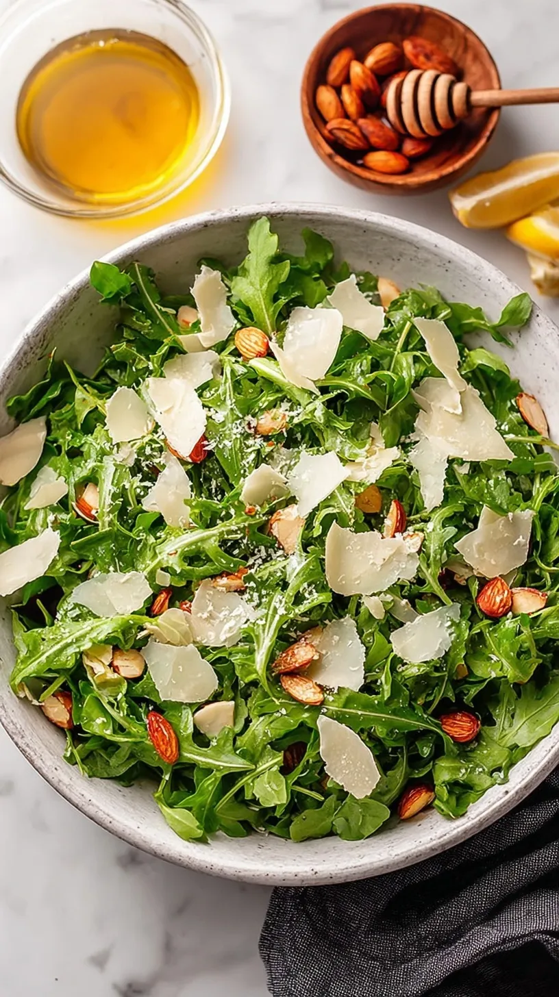 Fresh baby arugula salad with shaved parmesan cheese and lemon vinaigrette on a white plate