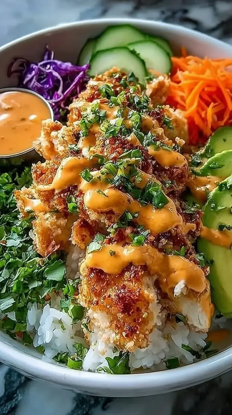 A vibrant Bang Bang Chicken Bowl with crispy glazed chicken, sliced cucumbers, and shredded carrots over white rice.