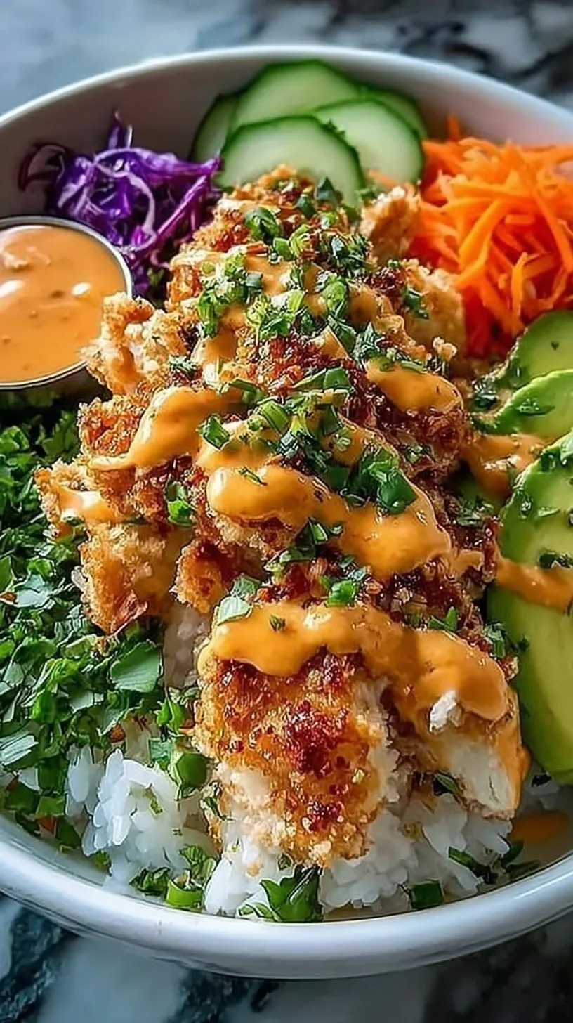 A vibrant Bang Bang Chicken Bowl with crispy glazed chicken, sliced cucumbers, and shredded carrots over white rice.