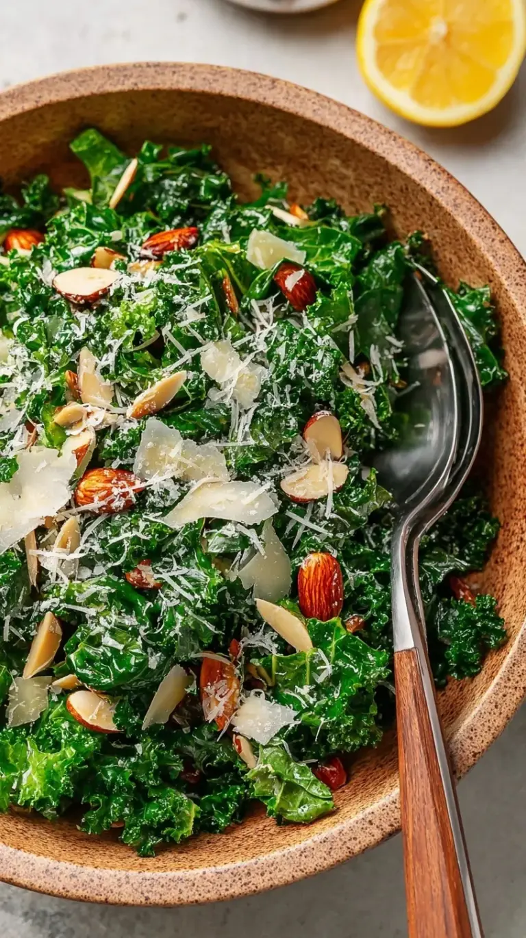A large bowl of massaged curly kale salad with dried cranberries, pumpkin seeds, and shaved parmesan.