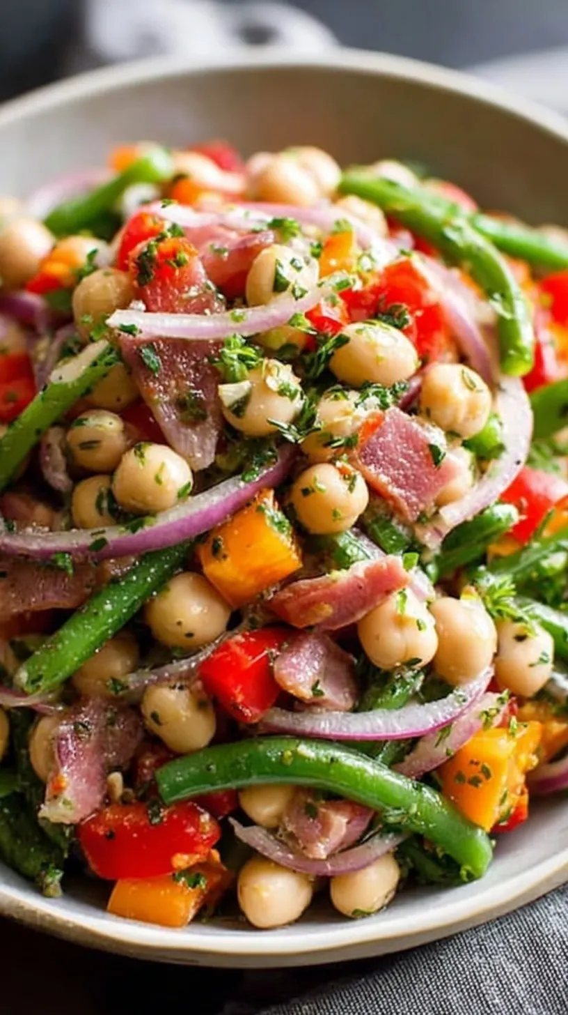 A colorful grinder bean salad in a large glass bowl with chickpeas, salami, and provolone.