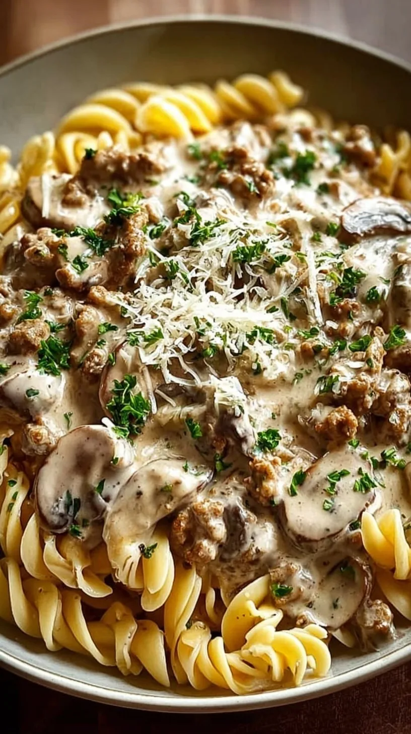 A bowl of creamy ground turkey stroganoff with mushrooms over wide egg noodles and fresh parsley