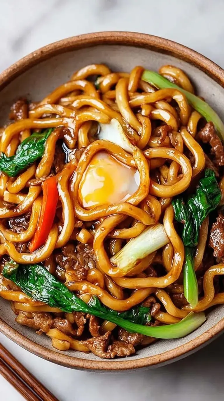 Steaming bowl of High Protein Yaki Udon with chicken, tofu, and fresh vegetables