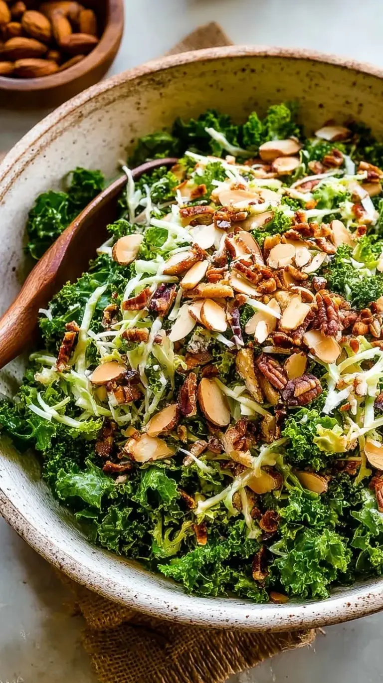 A large bowl of fresh kale crunch salad topped with roasted salted almonds