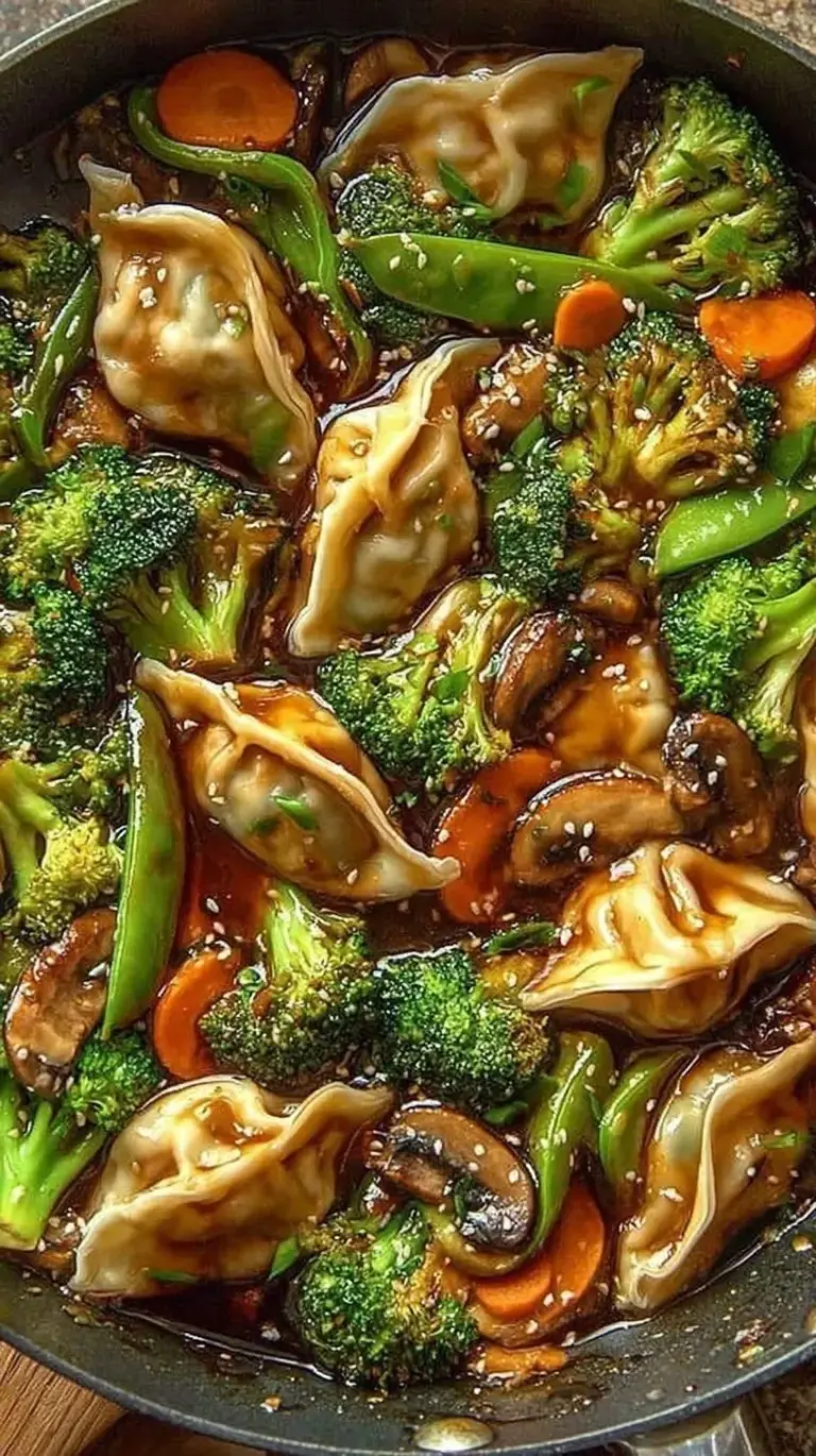 A vibrant skillet of golden potstickers, shredded cabbage, and red bell peppers garnished with green onions.
