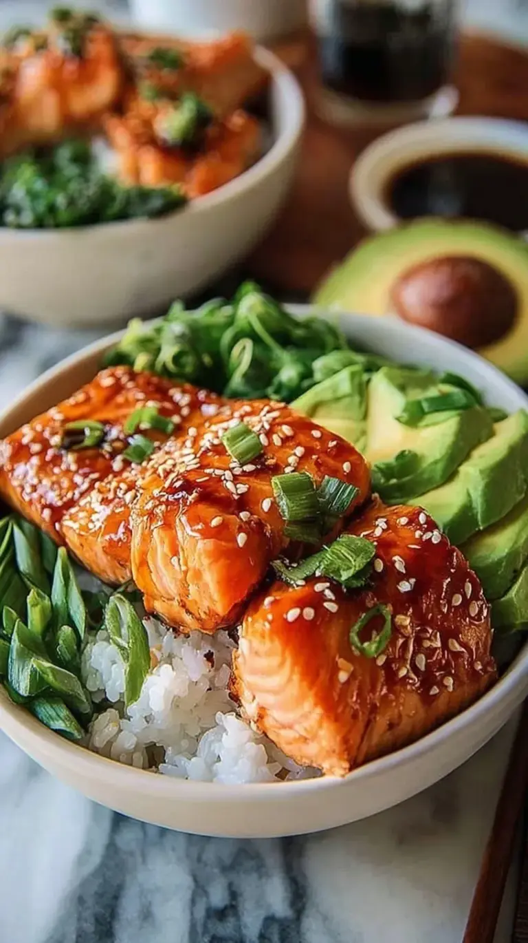 Two Salmon Rice Bowls with sliced avocado, cucumber, and spicy mayo drizzle on a modern table.