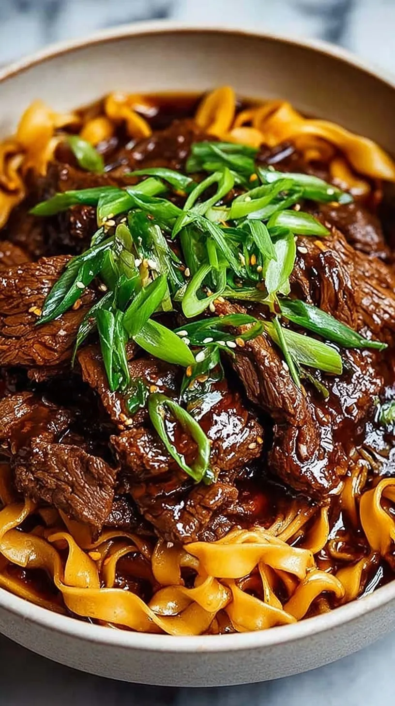 A bowl of slow cooker beef noodles topped with green onions and sesame seeds