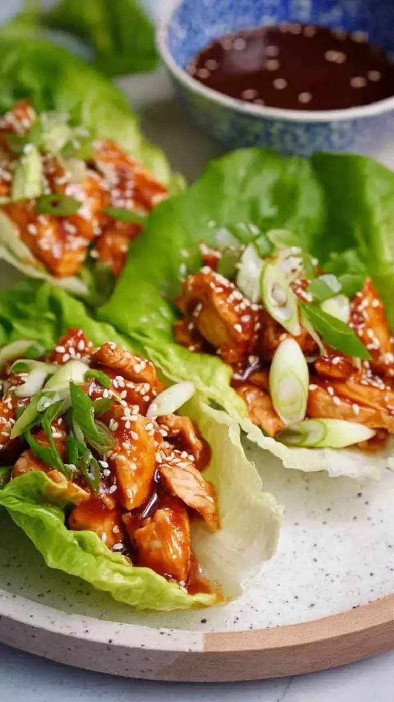 Ground chicken in butter lettuce cups topped with green onions and sesame seeds